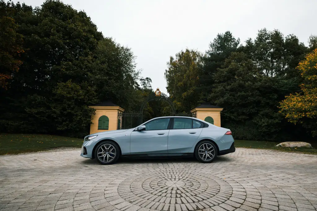 BMW-i5-Sida-ljugsblå-träd-bakgrund