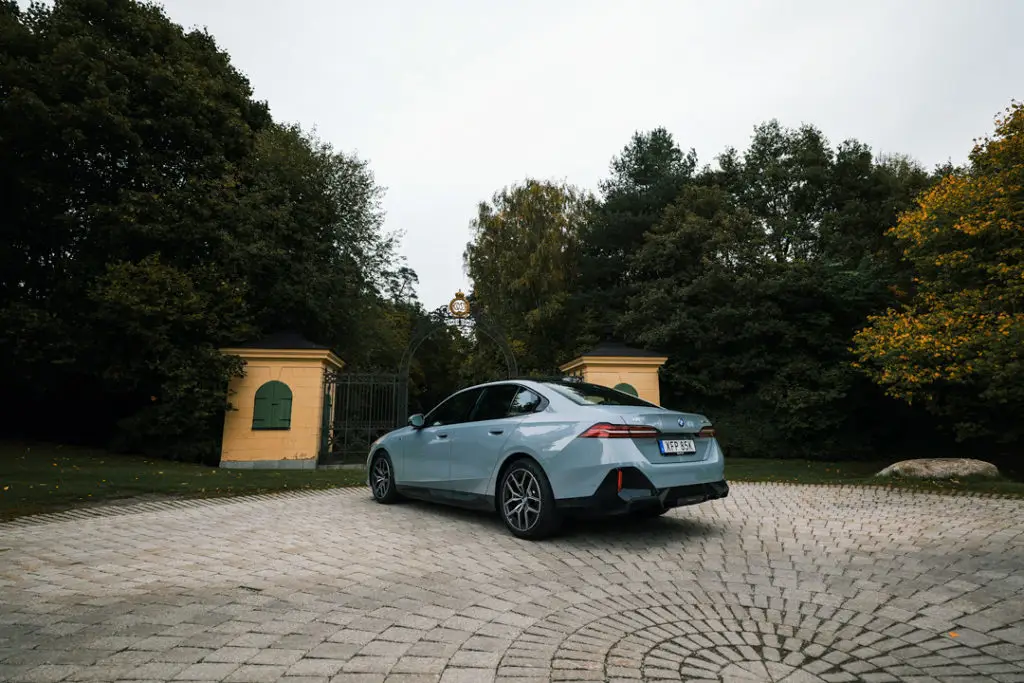 BMW-i5-Sida-Bak-ljusblå-träd-bakgrund